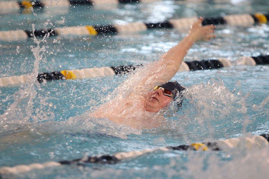 Competing in the 200-yard medley relay, senior Logan Myers backstrokes to switch off with a teammate.