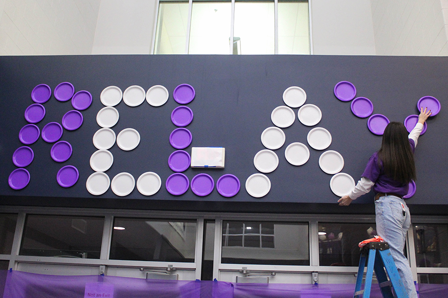 Using plates, senior Lauren Johnson creates a huge display that says RELAY on one side of the schools entrance. 