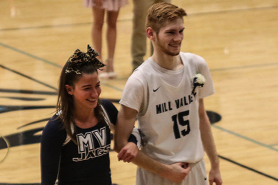 Homecoming king candidate Braeden Wiltse walks with senior Ellie Kerstetter, standing in for queen candidate Anna Paden, during the coronation at halftime of the boys varsity game Friday, Jan. 1.