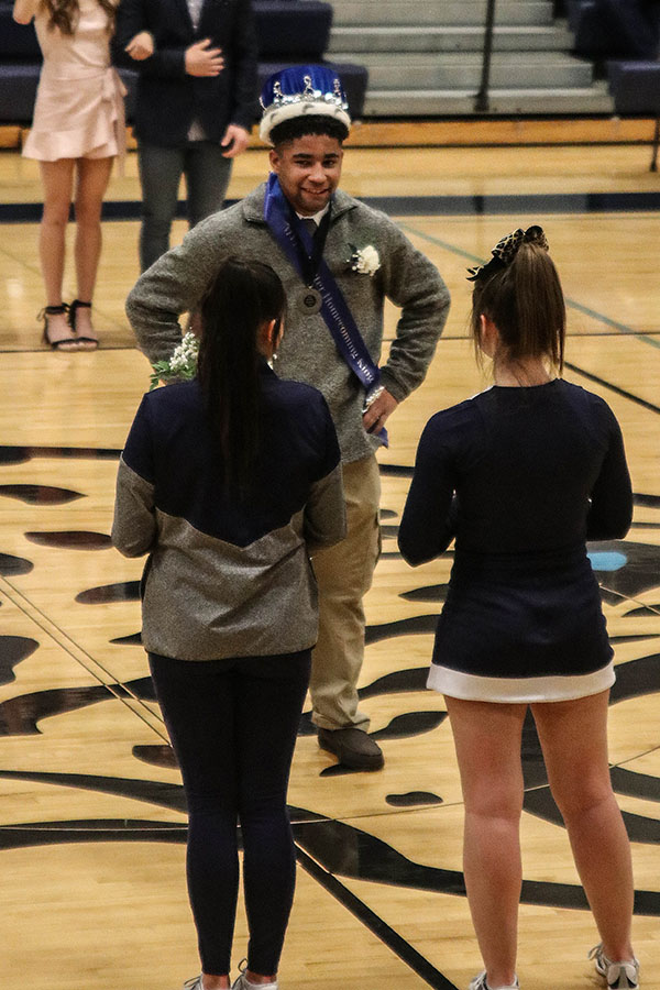 After being crowned king, senior Tyler Green stands alone as the crowd claps.