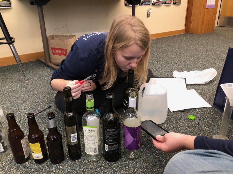 Prior to competing in Sounds of Music, senior Callie Roberts adjusts the pitch of each of the bottles by adding specific amounts of water and blowing into the bottle. The team of Roberts and junior Andrew Gawith made their project using different sizes of bottles and creating different notes by adjusting the water levels in each.