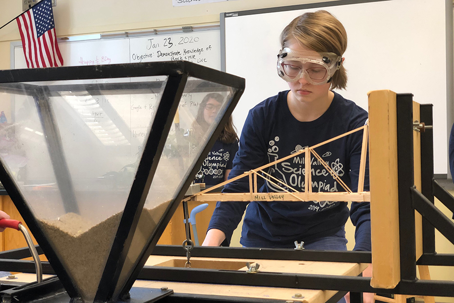 During her event Boomilever, senior Megan Overbaugh holds the sand bucket still as freshman Sydney Downey controls how fast the sand spills into the bucket. Boomilever is an event where a team of up to two aims to build the lightest suspension crane that can hold the most weight. Overbaugh and Downeys crane was able to hold the entire bucket of sand, placing them second overall at the Pembroke Hill Invitational Saturday, Jan. 25.