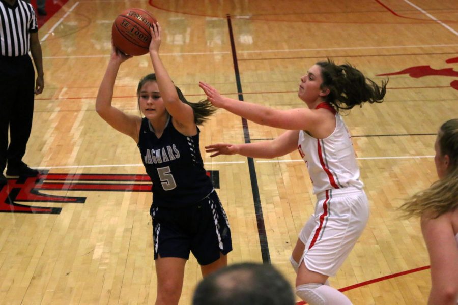 Avoiding an opponent, junior Delaney Fields passes the ball.