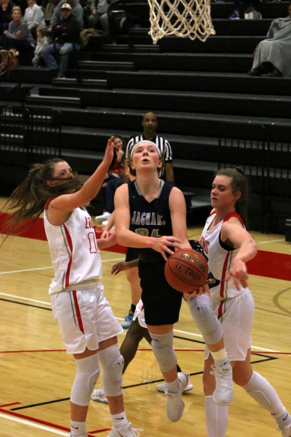 Holding the ball, sophomore Emree Zars attempts to shoot a basket.