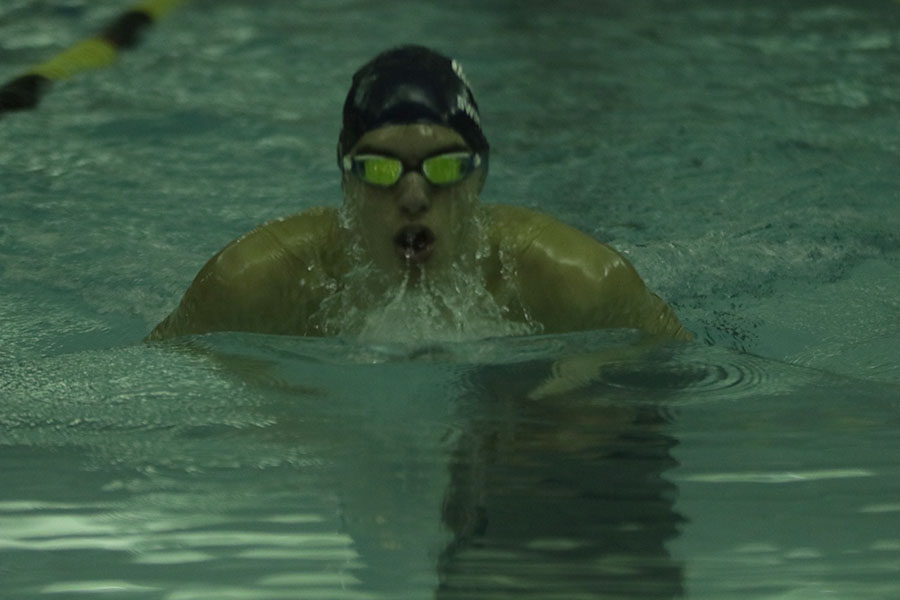 Taking a breath, junior Cole McClure swims the 100 meter breaststroke.