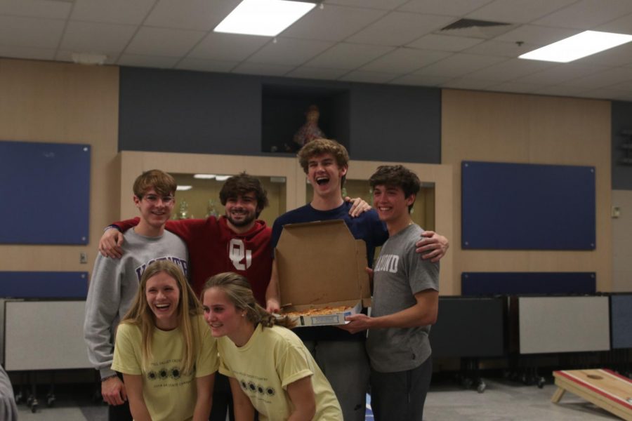 At the end of the cornhole tournament English teacher Cathy Stevens and her husband came out on top. All of the top three teams took a picture with the fourth place prize, a full pizza.