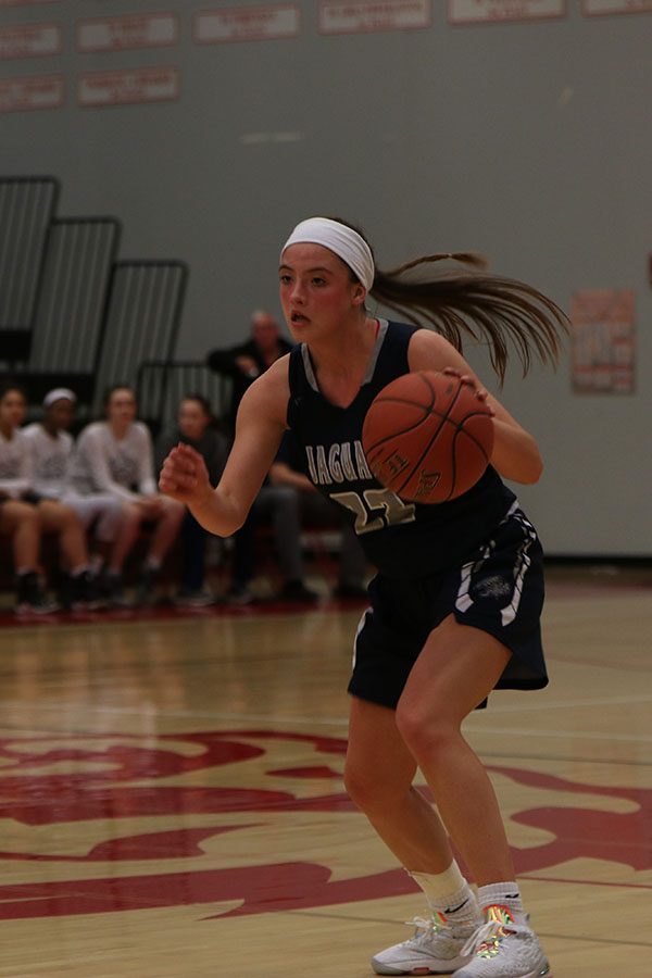 Dribbling the ball at mid court, junior Katherine Weigel prepares to pass the ball.
