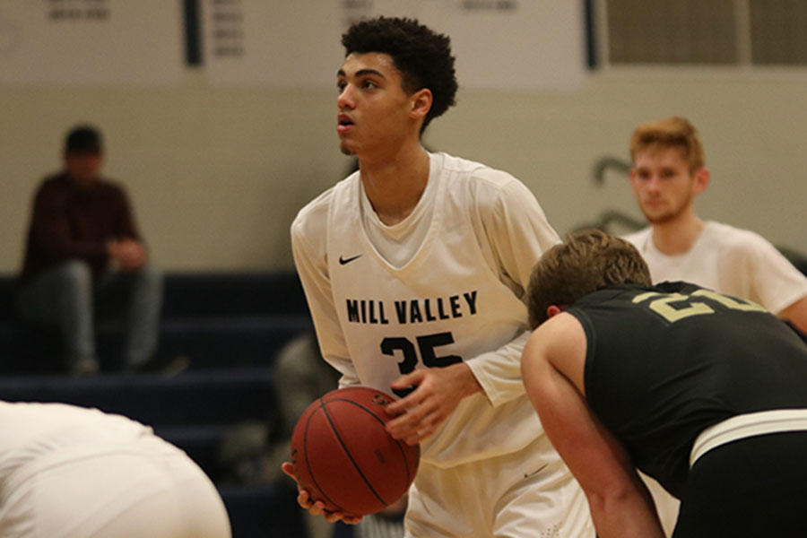 Staying focused, sophomore Adrian Dimond gets ready to shoot a free throw, making it and scores a point. The team lost to Blue Valley Jan. 14, the final score being 65-52.