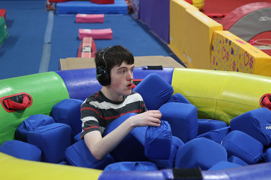 Sitting in a foam pit sophomore John Carl, plays with the foam cubes at Pinnacle Gymnastics on Thursday, Jan. 23. 