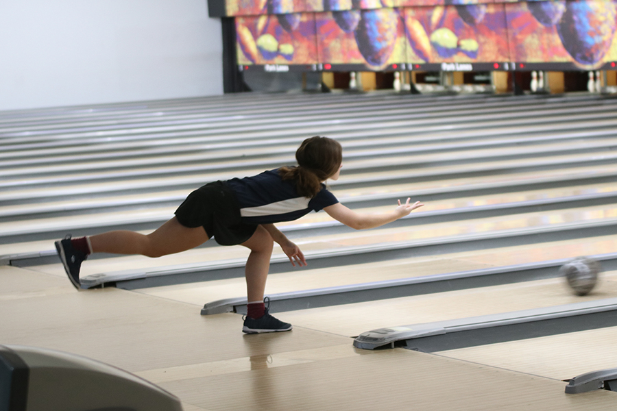 Attempting to knock over the pins, junior Avery Norman releases the ball.