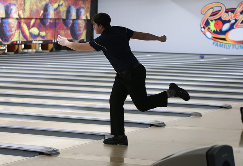 Leaning forward, junior Devin Kuhlman watches the ball roll down the lane. The bowling team claimed first in every category at the St. James meet Thursday, Jan 23.