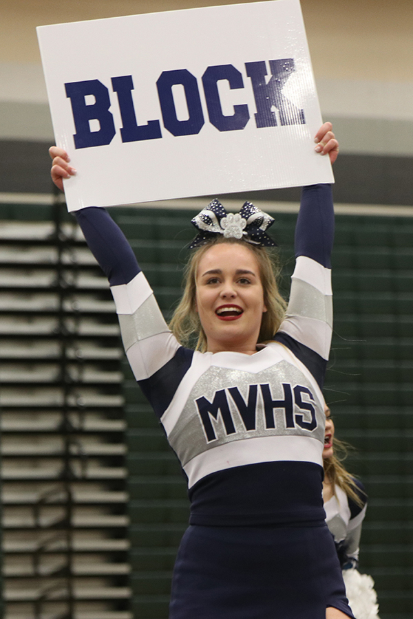 Looking out to the crowd, junior Chloe Carson puts on a smile while holding up a sign.  
