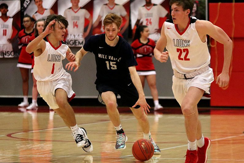 After getting the rebound, senior Braeden Wiltse dribbles the ball down the court while being defended by the opposing team. On Friday, Jan. 31, boys basketball fell Lansing with a final score of 75-60.