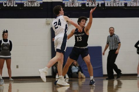 While on defense, junior Pete Janssen guards the Blue Valley North player from passing the ball. On Friday, Feb. 21, the boys basketball team fell to Blue Valley North with an end score of 95-69.