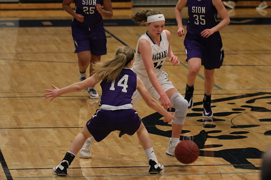 Dribbling towards the goal, sophomore Emree Zars avoids a defender.