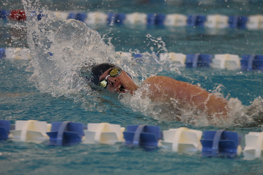 Coming up for air, junior Noah Collins competes in the 400-yard freestyle relay at the state meet on Friday, Feb. 21 and Saturday, Feb. 22. The team placed 9th overall at state.