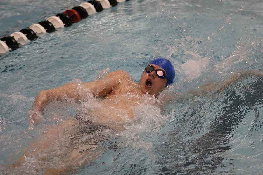 Competing in the 200-yard IM, junior Noah Collins does the backstroke.