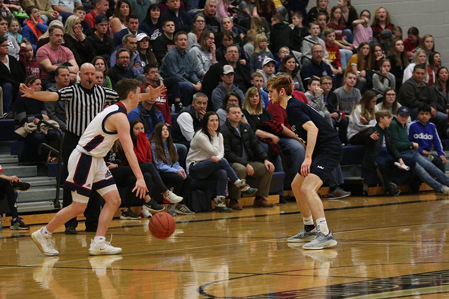 Guarding an offensive player, senior Braeden Wiltse watches the ball closely. On Friday, Feb. 7, boys basketball fell to St. James in an end score of 52-42. 