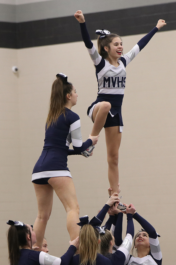Held by her teammates, freshman Sidney Claeys stands in formation with teammate junior Claire Dinslage.