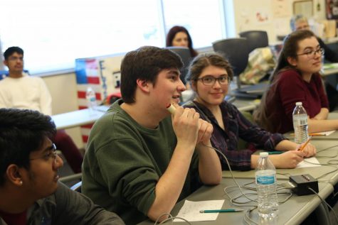 Laughing with the speaker, senior Noah Hookstra cracks a joke after answering a question correctly. The Quiz Bowl team made it to championship rounds at the regional tournament Thursday, Feb. 3. 