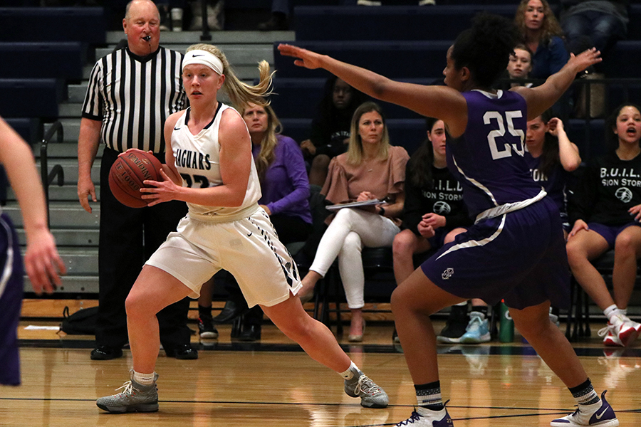 Holding the ball, junior Elle Zars runs past an opponent.