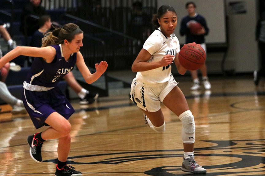 Running toward the basket, junior Vania Barnett avoids a defender. The team defeated Notre Dame de Sion 44-40 Tuesday, Feb. 26 on senior night.