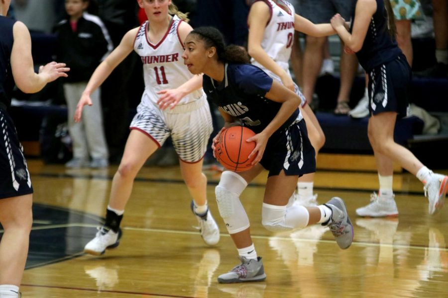 With the ball in hand, junior Vania Barnett dodges her opponents.