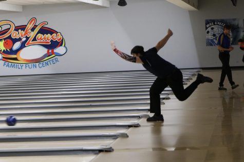 Throwing the ball, junior Devin Khulman extends his arm toward the pins. The Mill Valley Bowling team competed at regionals at Park Lanes Thursday, Feb. 27.