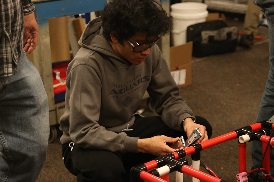 Getting ready to fix the machine, senior Nico Gatapia uses a tool.