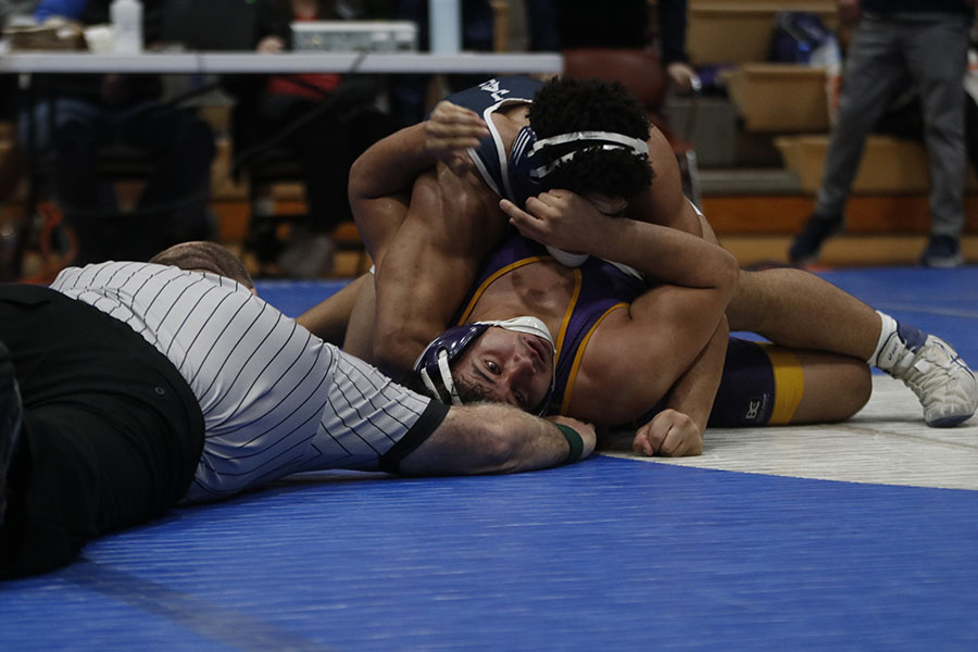 On his way to the match victory, senior Tyler Green pins his opponent.