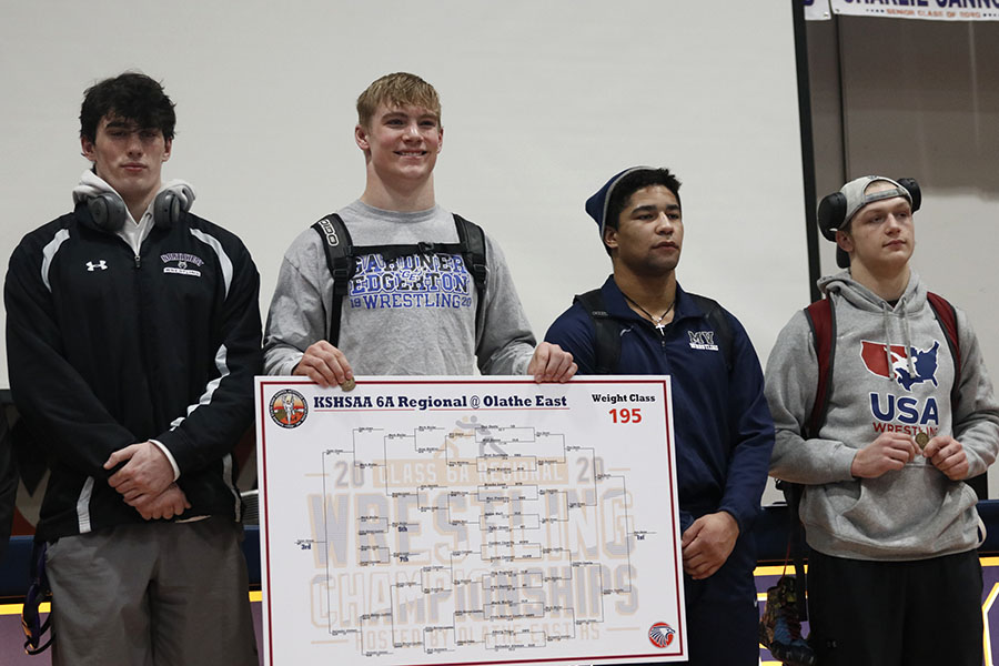 Placing third in the 195-pound weight class, senior Tyler Green stands on the podium.