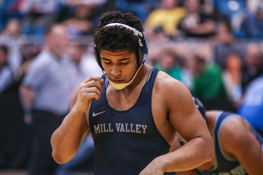 Waiting for his opponent on the mat, senior Tyler Green gets ready for match. 