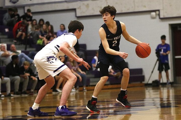 Guarding the ball from the defender, senior Christian Macias dribbles across the court Wednesday, March 4 playing against Blue Valley Northwest in a 80-56 loss. 