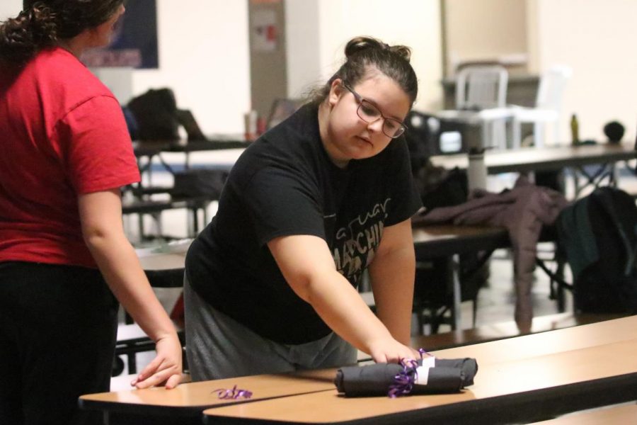 After getting t-shirts for the show, junior Abigail Peters helps hand them out to the cast.