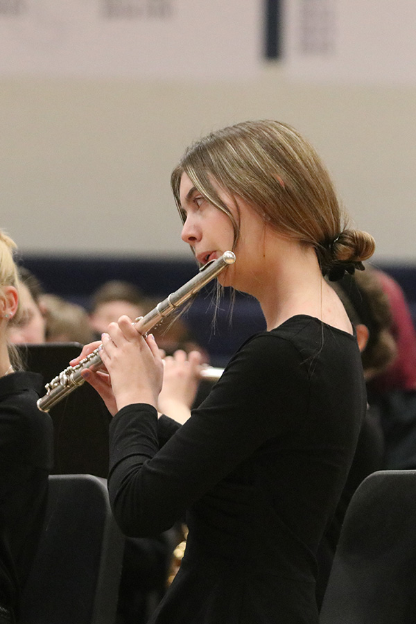 In the front of the group of performers, junior Claire Burke plays the flute for the audience.