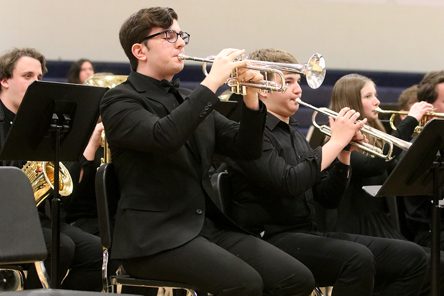 Playing for the audience, senior Jason Kingsbury solos in the middle of the song standing out of the crowd.
