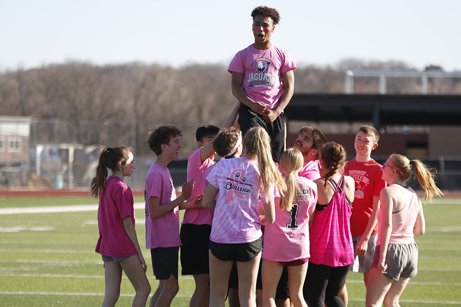 Yelling, freshman Sidney Lockhart is held up by his teammates.