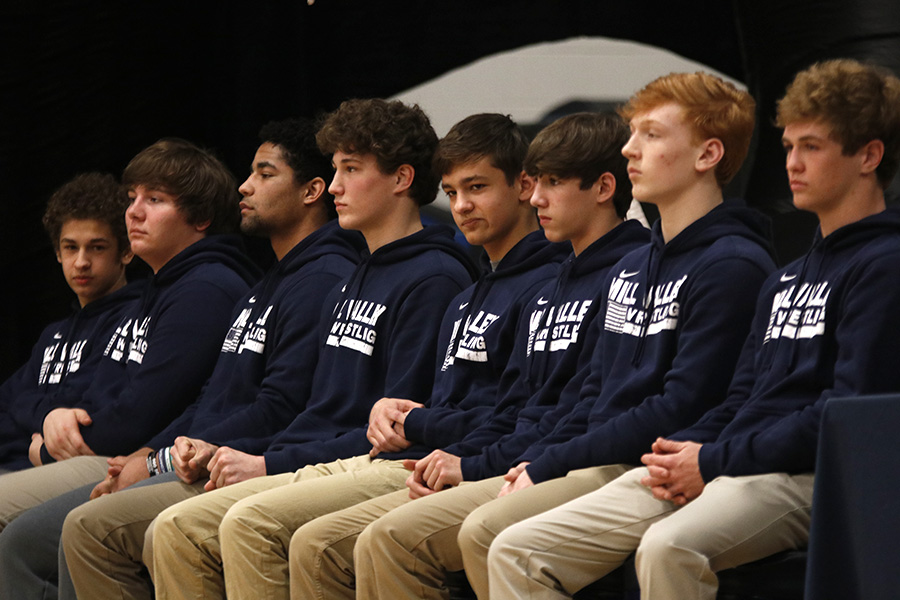 Members of the varsity wrestling team look out into the crowd as speakers congratulate them on their state title.