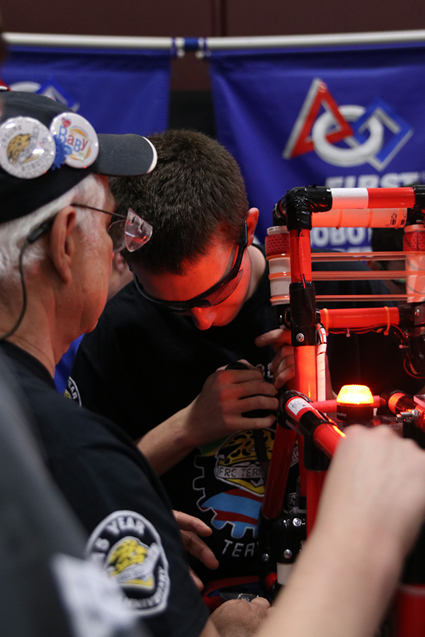 Between matches, senior Brett Bellmyer assists in reinforcing a part of the robot damaged by another team’s robot in their previous match.  