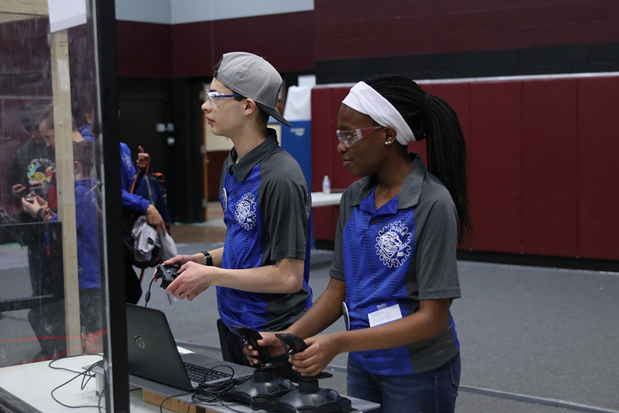 Practicing between matches, juniors Courtney Mahugu and Alex Whipple take commands from their mentors on the practice field to examine the faults from the previous match.