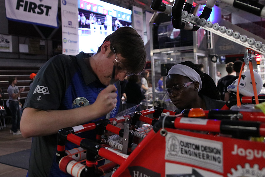 After making edits to the robot in the pit, senior Jacob Howe files a part of the robot, minutes before their next match starts. 