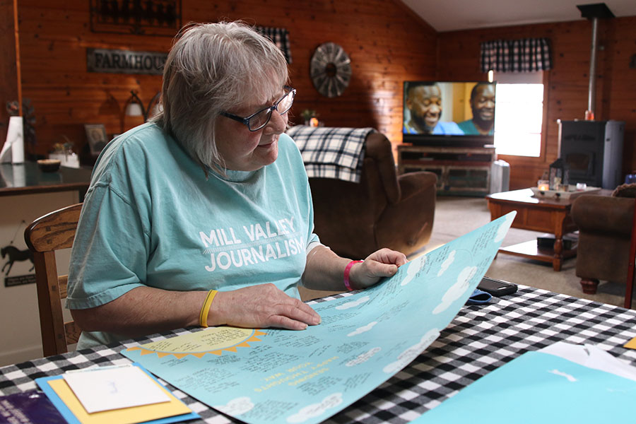 Custodian Rhonda Jensen smiles as she reads a get well soon card from journalism students. Jensen believes that she will be out of work until May so the community, faculty and students banned together to raise money to support her while she is on leave for staph infection treatment. 