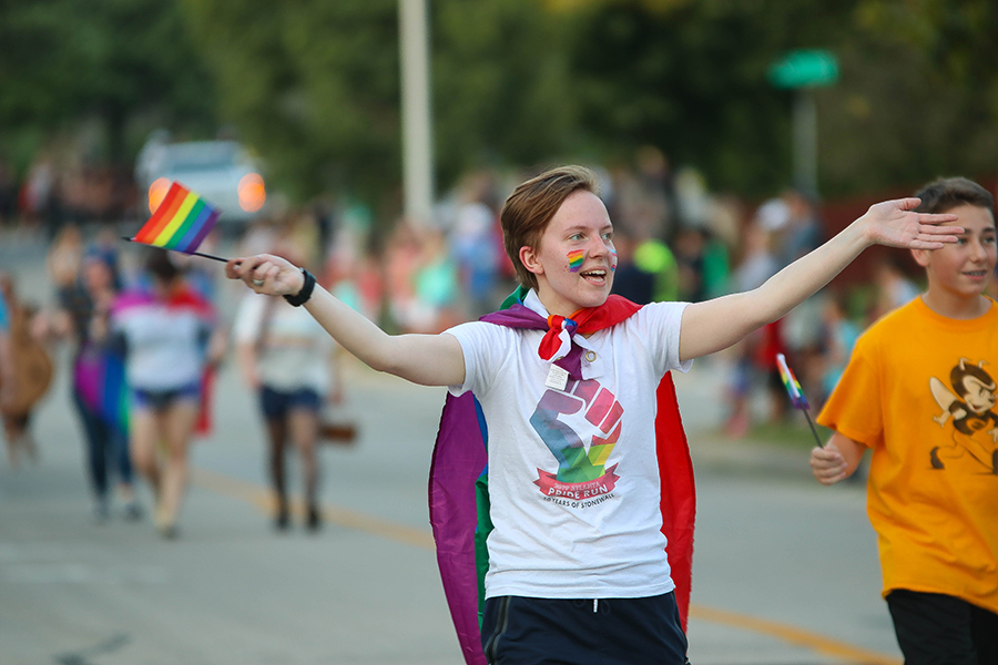 Walking alongside the gay-straight alliance float during the annual homecoming parade Wednesday, Sept. 18, senior Jay Zuch waves the pride flag to promote the club. “A lot of people think being part of the LGBT community is a bad thing, but we’re just normal human beings being ourselves,” Zuch said.” Being in the gay-straight alliance club has given me a place that I feel welcomed and accepted by everyone. At the beginning of high school, I was scared to be myself, but other members of GSA showed me that I could love who I truly am.”