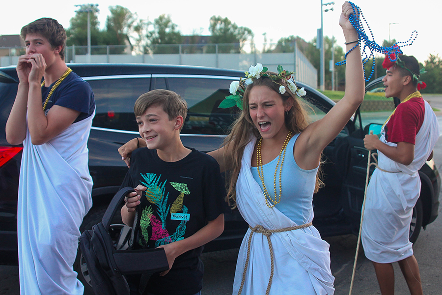 Continuing the tradition of welcoming freshmen by cheering when they arrive, senior vice president Avery Altman guides freshman Collin Scherzer to the activities entrance for orientation Wednesday, Aug. 14. “We want everyone to have their first impression of their new school as somewhere that anyone is welcome. By making sure they come in for the first time smiling it starts off their high school career on a positive note,” Altman said. “Freshman orientation is my favorite part about being on the student council because of the positive impact I can make on new students. It reminds me of why I put so many hours towards student council.”