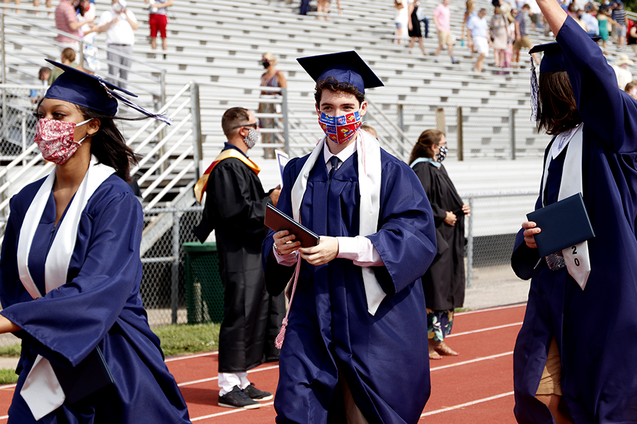 Senior Cael Duffin carries his diploma with him as he exits the field after the graduation ceremony ends. 
