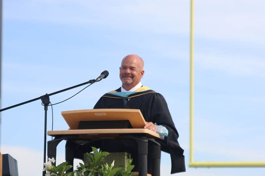 Looking across the field, principal Tobie Waldeck pauses and chokes up during his final graduation speech as principal.