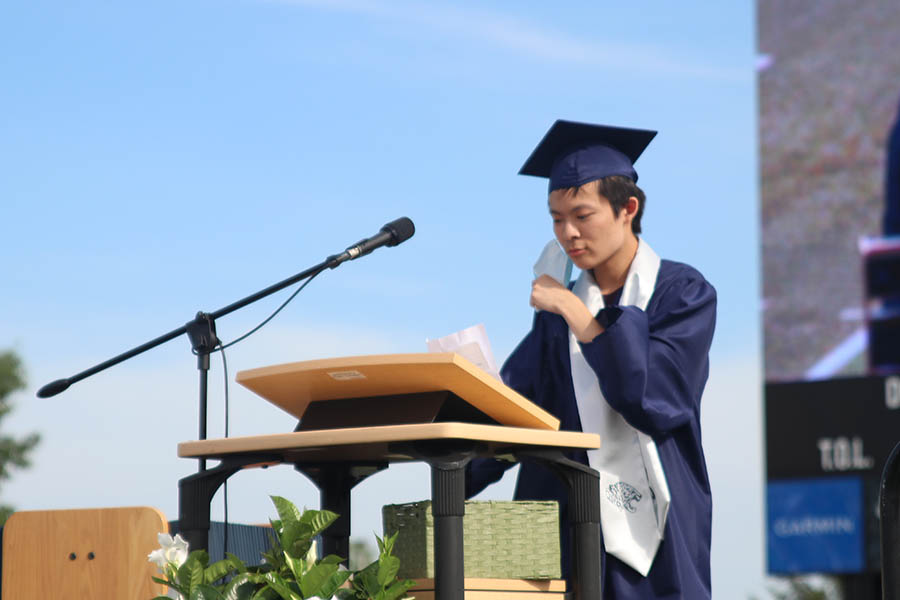 Taking off his mask, senior Kevin Lee prepares to give his speech as valedictorian. 