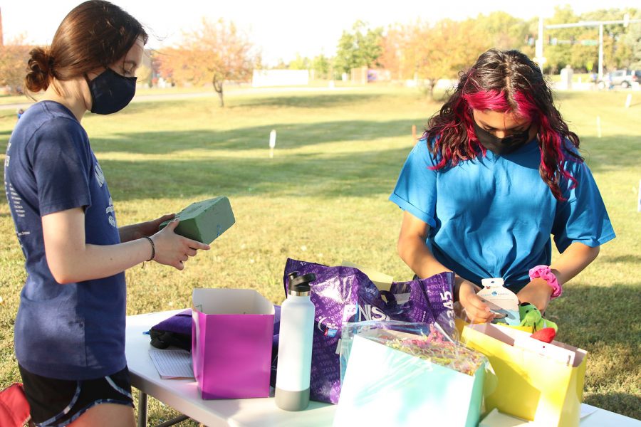 Setting up, junior Maddie Anderson and junior Olivia Franco set up the boxes for the silent auction.