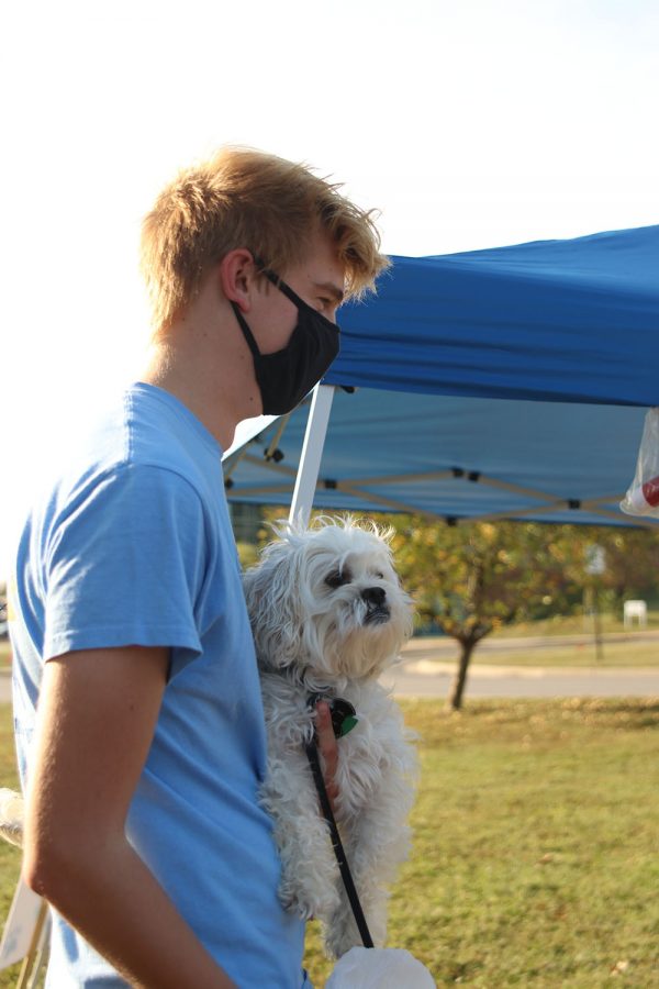 Waiting in line, junior Bret Weber holds his dog, Bo.