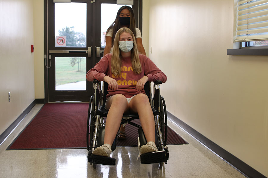 Pushing junior Kelly Doyle in the wheelchair, junior Jada Eggleston practices wheelchair use. 